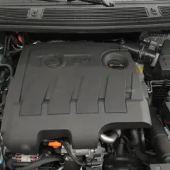 Silnik 1.6 TDI z widocznym logo TDI na pokrywie. Widać zbiornik płynu chłodniczego i elementy układu dolotowego.