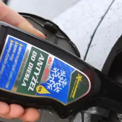 Ręka wylewa dodatek do diesla, chroniący silnik przed zamarzaniem.