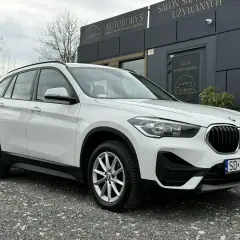 Białe BMW X1 2020 zaparkowane przed salonem samochodowym Autoborys.