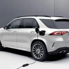 Biały SUV Mercedes-Benz jest ładowany. Zastanawiasz się, czy warto kupić hybrydę? Ten model pokazuje przyszłość motoryzacji.