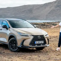 Mężczyzna prezentuje jeden z najnowszych lexus suv modele na tle surowego krajobrazu z morzem i górami.