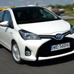 Biała Toyota Yaris 1.3 benzyna w ruchu. Zastanawiasz się, ile pali Toyota Yaris 1.3 benzyna? Ten model jest znany z oszczędności.