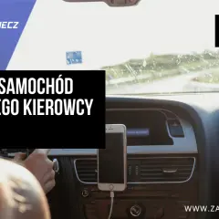 Pierwszy samochód dla młodego kierowcy. Widok z perspektywy kierowcy na deskę rozdzielczą, telefon na uchwycie i drogę przed autem.