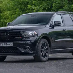 Czarny Dodge Durango 5.7 Hemi z polskimi tablicami rejestracyjnymi stoi na tle zieleni.