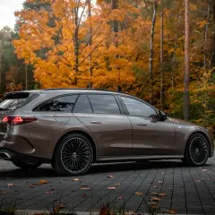 Elegancki Mercedes E300de kombi na tle jesiennego lasu.