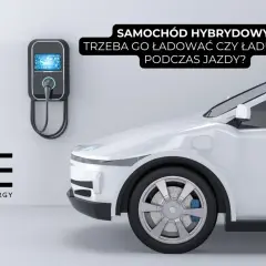 Biały samochód hybrydowy przy ładowarce ściennej. Czy trzeba go ładować, czy ładuje się podczas jazdy?