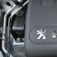 Element mocowania silnika Peugeot, gotowy do wymiany poduszki silnika. Widoczny symbol lwa i napis HDi.