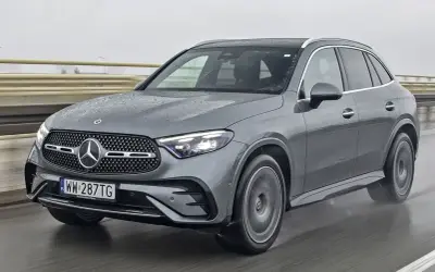 Szary Mercedes GLC 300d na mokrej drodze, z widocznymi kroplami deszczu na karoserii.