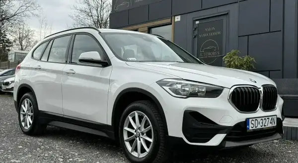 Białe BMW X1 2020 zaparkowane przed salonem samochodowym Autoborys.