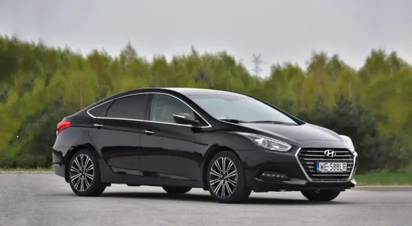 Czarny Hyundai i40 1.7 CRDi na tle drzew. Choć auto prezentuje się elegancko, warto znać jego potencjalne wady przed zakupem.