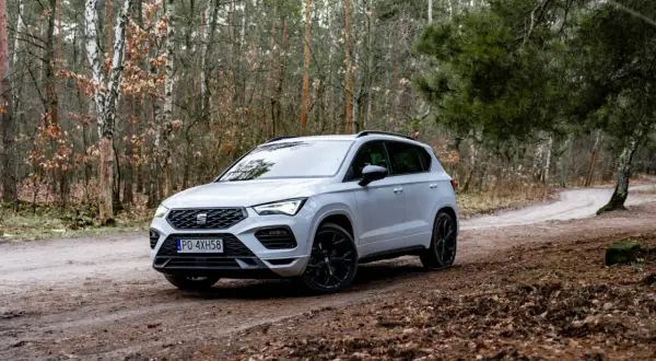 Biały Seat Ateca na leśnej drodze, gotowy na przygodę.