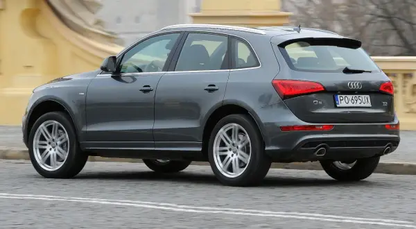 Szary Audi Q5 8R w ruchu miejskim, z widocznym tyłem i bokiem pojazdu.