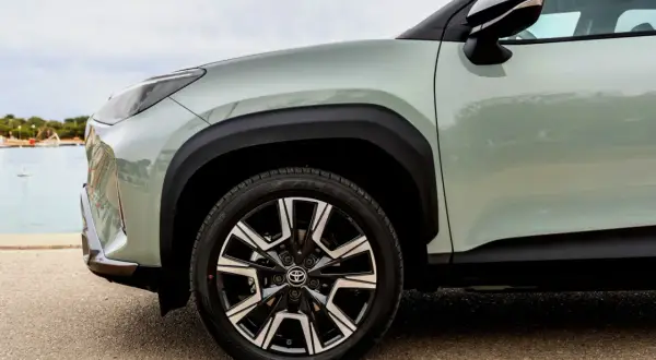 Zbliżenie na zielony Toyota Yaris Cross z czarnymi felgami. Idealny do miasta, niskie spalanie.