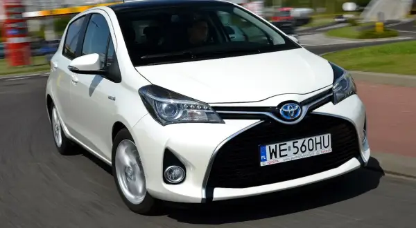 Biała Toyota Yaris 1.3 benzyna w ruchu. Zastanawiasz się, ile pali Toyota Yaris 1.3 benzyna? Ten model jest znany z oszczędności.
