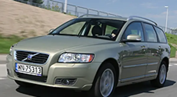 Złoty Volvo V50 2.0D na drodze, z widocznym kierowcą za kierownicą.