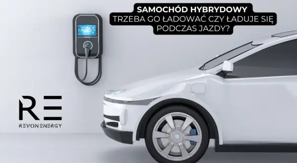 Biały samochód hybrydowy przy ładowarce ściennej. Czy trzeba go ładować, czy ładuje się podczas jazdy?