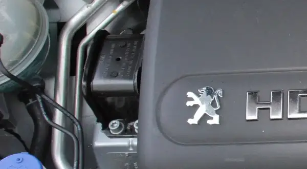 Element mocowania silnika Peugeot, gotowy do wymiany poduszki silnika. Widoczny symbol lwa i napis HDi.