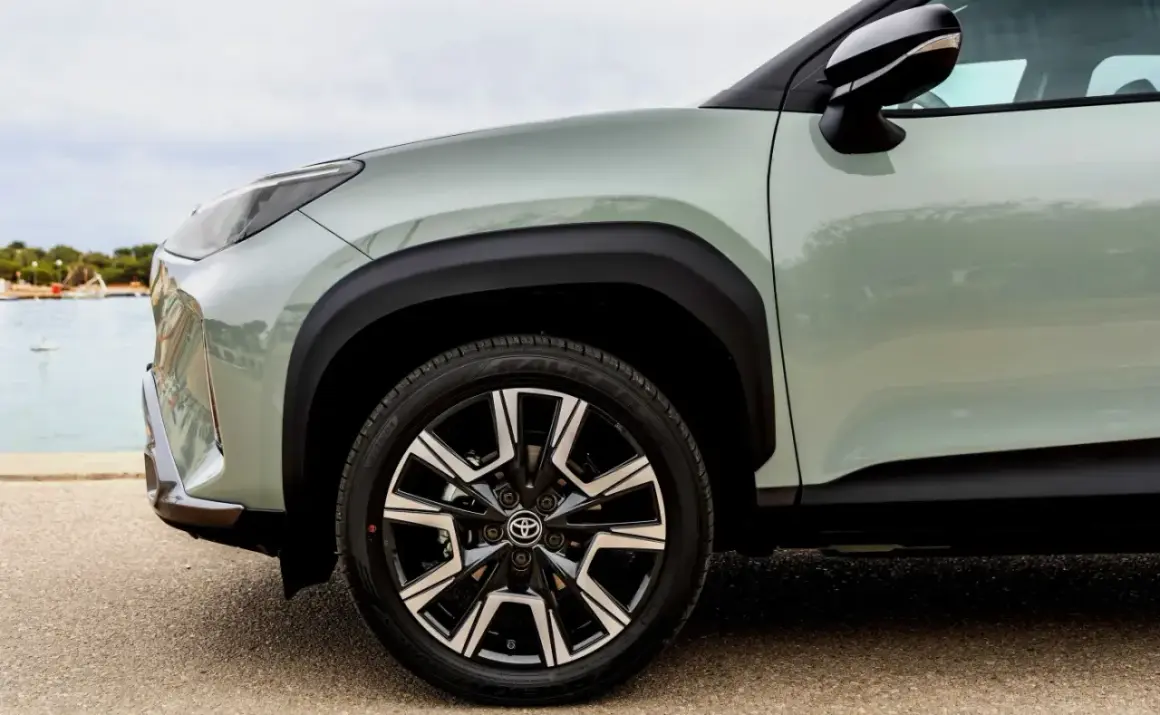 Zbliżenie na zielony Toyota Yaris Cross z czarnymi felgami. Idealny do miasta, niskie spalanie.