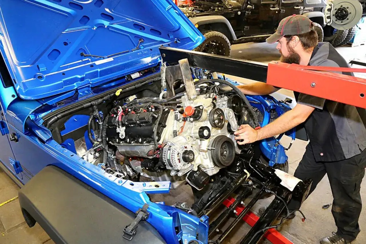 Mechanik pracuje nad silnikiem Jeepa. Różne rodzaje silników są kluczowe dla wydajności pojazdu.