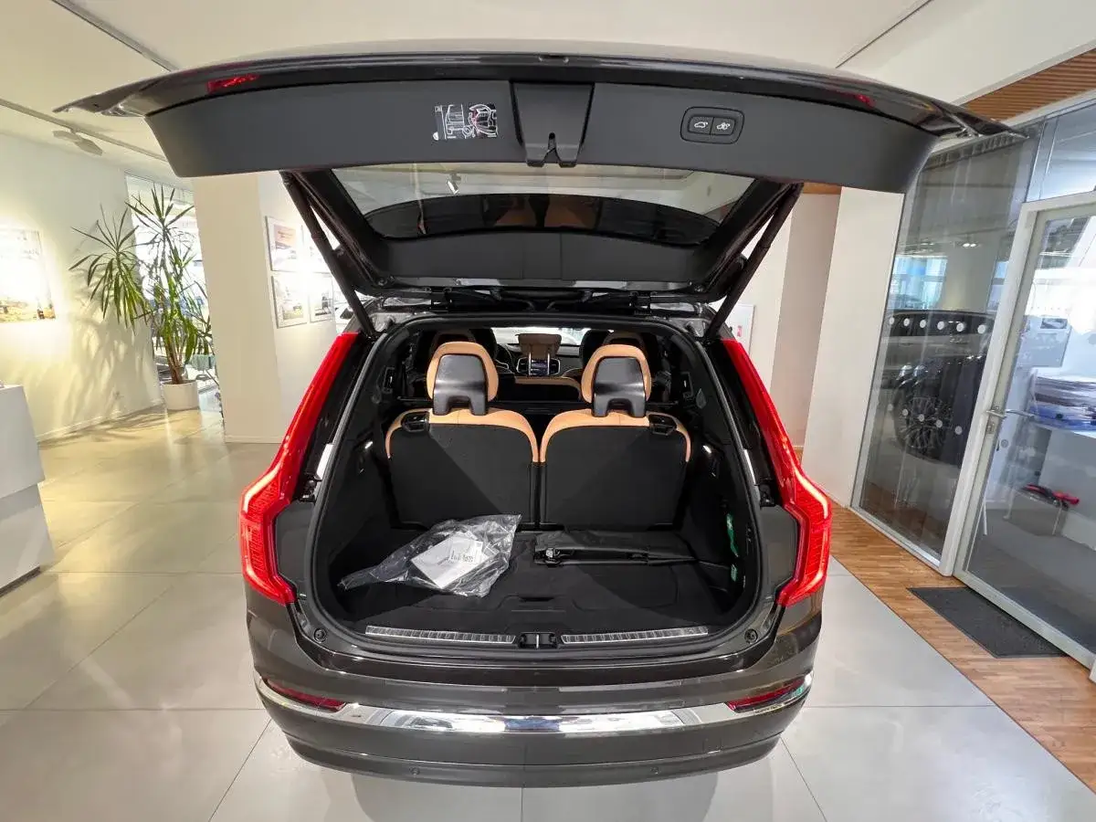 Wnętrze Volvo XC90 T8 z otwartą klapą bagażnika. Widoczne jasne fotele i podłoga bagażnika.