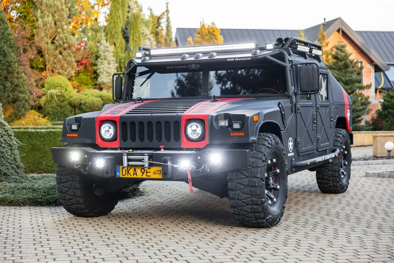 Czarny Hummer H3 z czerwonymi akcentami i dodatkowym oświetleniem LED, gotowy na każdą przygodę.