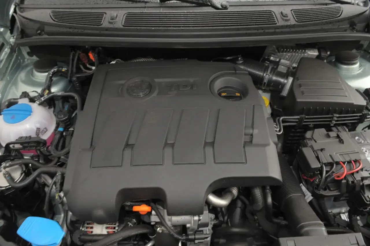 Silnik 1.6 TDI z widocznym logo TDI na pokrywie. Widać elementy układu dolotowego i chłodzenia.