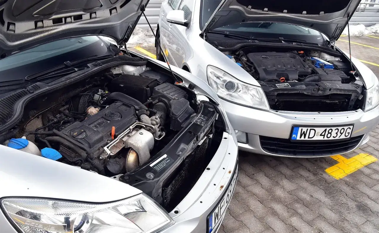 Dwa srebrne samochody z otwartymi maskami. Który silnik wybrać: benzyna czy diesel?