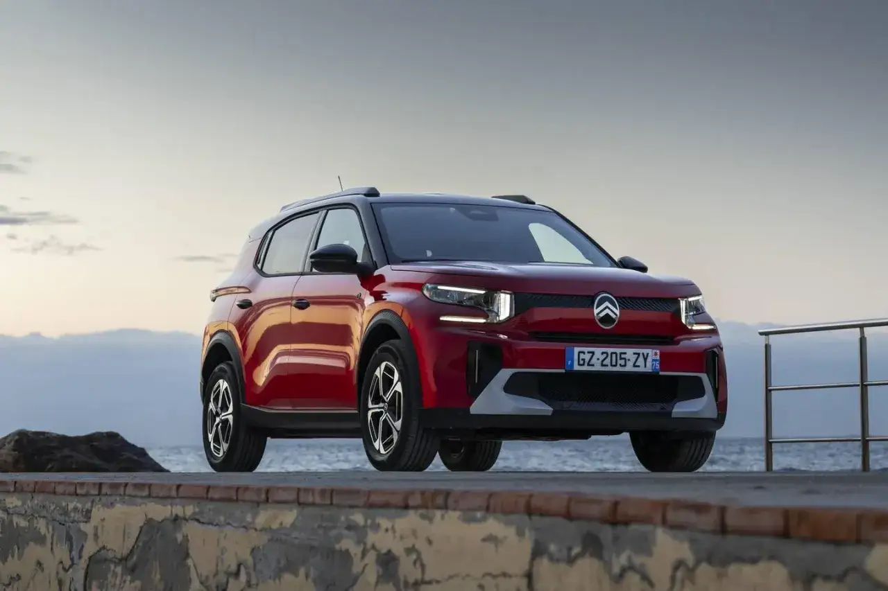 Nowy, czerwony Citroën C3 Aircross stoi na nadmorskiej promenadzie, gotowy na przygodę.