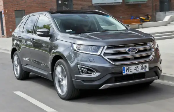 Szary Ford Edge 2.0 Ecoboost w ruchu miejskim.