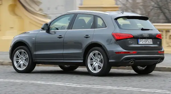 Szary Audi Q5 8R w ruchu miejskim, z widocznym tyłem i bokiem pojazdu.