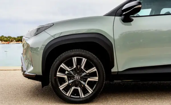 Zbliżenie na zielony Toyota Yaris Cross z czarnymi felgami. Idealny do miasta, niskie spalanie.