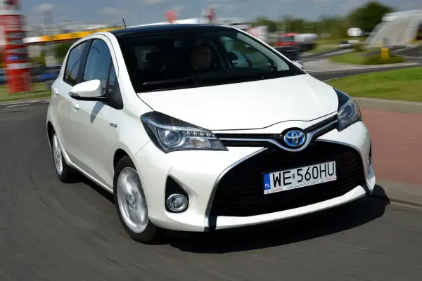 Biała Toyota Yaris 1.3 benzyna w ruchu. Zastanawiasz się, ile pali Toyota Yaris 1.3 benzyna? Ten model jest znany z oszczędności.
